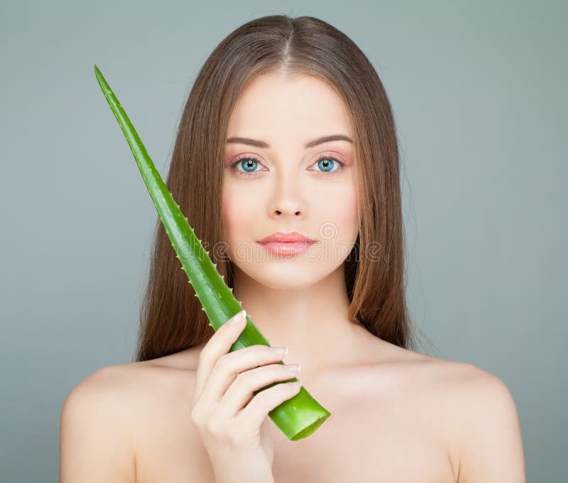 Modell Woman med den gulliga framsidan, ny hud och gräsplanaloebladet arkivbild Modell Woman med den gulliga framsidan, ny hud och gräsplanaloebladet arkivbild