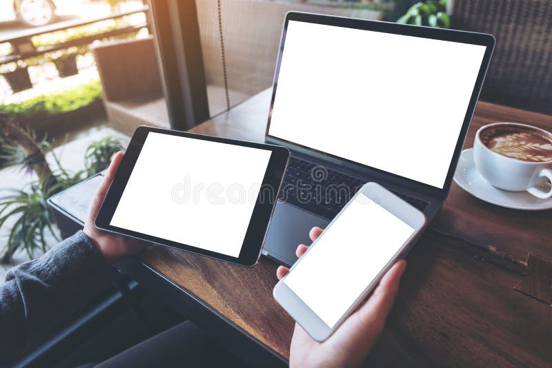 Modellbild einer Geschäftsfrau, die weißen Handy, schwarze Tablette und Laptop mit leerem weißem Schirm hält lizenzfreies stockbild Modellbild einer Geschäftsfrau, die weißen Handy, schwarze Tablette und Laptop mit leerem weißem Schirm hält lizenzfreies stockbild
