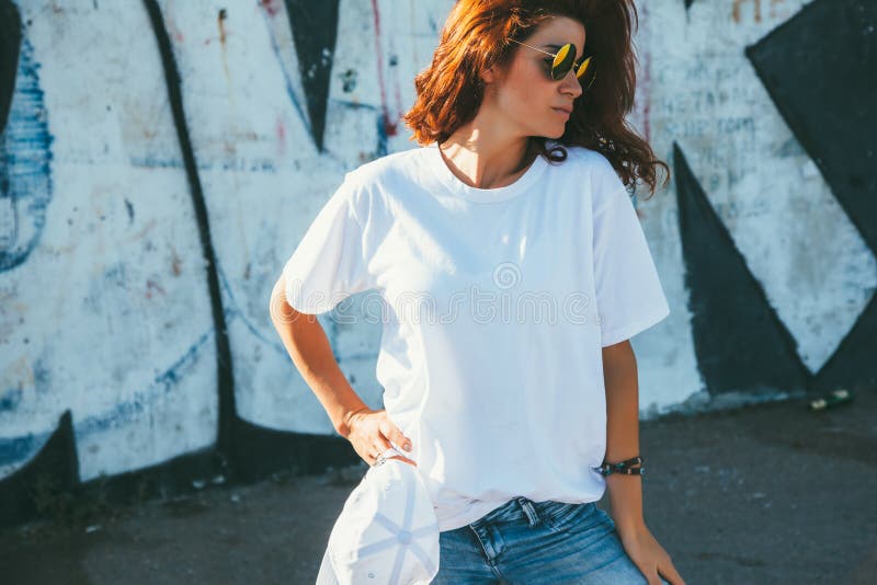 Model wearing plain white tshirt and hipster sunglasses posing against street wall, teen urban clothing style. Model wearing plain white tshirt and hipster sunglasses posing against street wall, teen urban clothing style