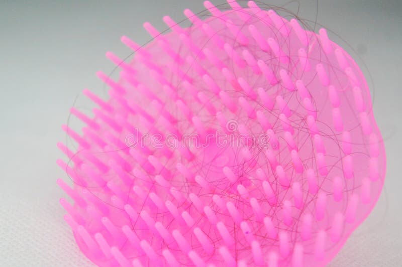 Modello esclusivo di pettine rosa rotondo in plastica all'interno del quale sono fissati i capelli. immagini stock libere da diritti