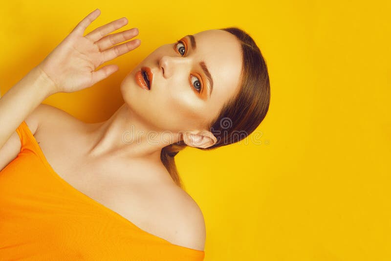 Modello Girl di bellezza con trucco professionale giallo/arancio Donna arancio di modo del rossetto e dell'ombretto con capelli l immagine stock libera da diritti Modello Girl di bellezza con trucco professionale giallo/arancio Donna arancio di modo del rossetto e dell'ombretto con capelli l immagine stock libera da diritti