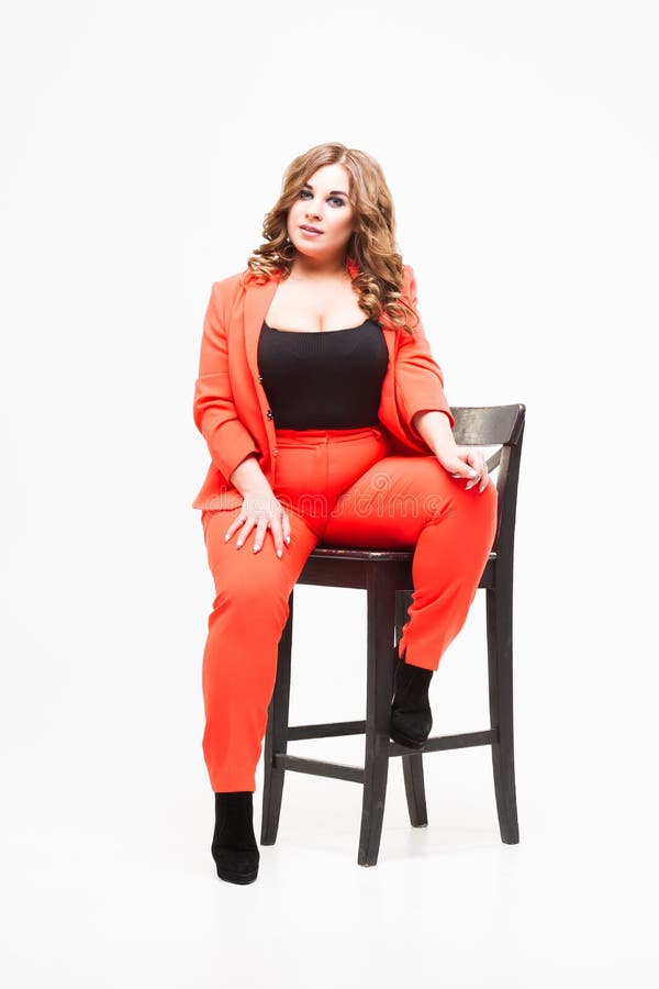 Modello pi? di dimensione con il grande seno e la donna decollete e grassa profonda su fondo bianco in pantsuit arancio, concetto immagini stock Modello pi? di dimensione con il grande seno e la donna decollete e grassa profonda su fondo bianco in pantsuit arancio, concetto immagini stock