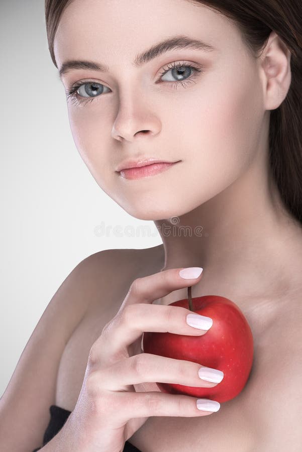 Modelo com a composição natural que guarda uma maçã O conceito da beleza e da saúde imagem de stock Modelo com a composição natural que guarda uma maçã O conceito da beleza e da saúde imagem de stock