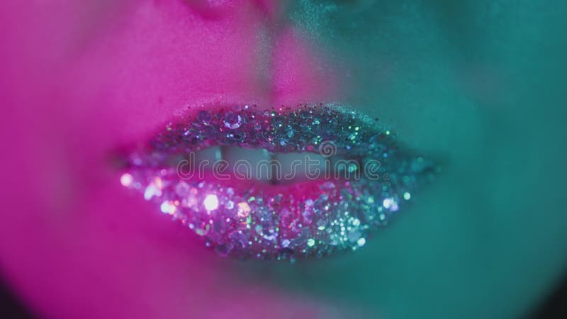 Modelo de alta moda labios metálicos de plata y mujer de cara en neón brillante colorido uv luces azul y púrpura posando en metrajes