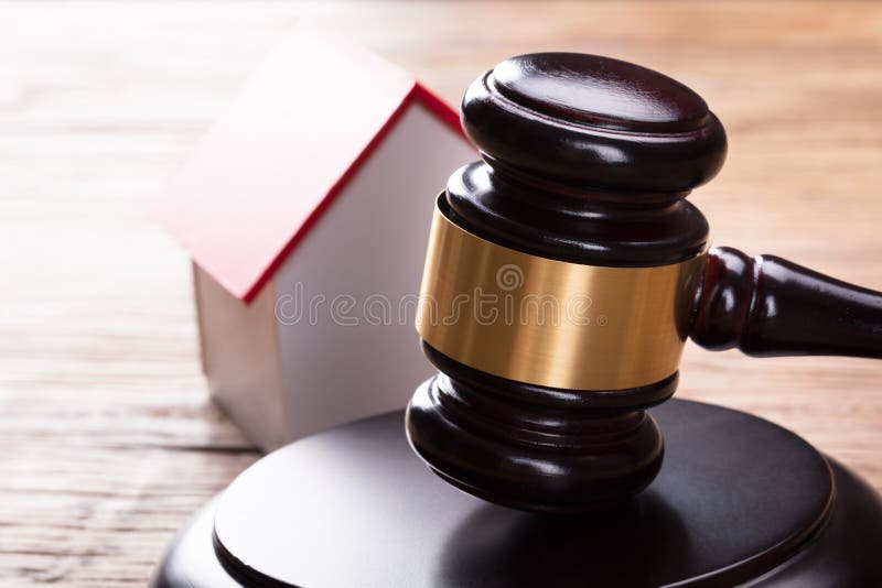 Close-up Of House Model With Gavel On Wooden Table. Close-up Of House Model With Gavel On Wooden Table