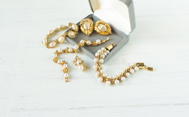 Modelo de fôrma Jewelry Fundo da joia do vintage Braceletes e brincos bonitos da pérola em uma caixa de presente na madeira branc imagens de stock Modelo de fôrma Jewelry Fundo da joia do vintage Braceletes e brincos bonitos da pérola em uma caixa de presente na madeira branc imagens de stock
