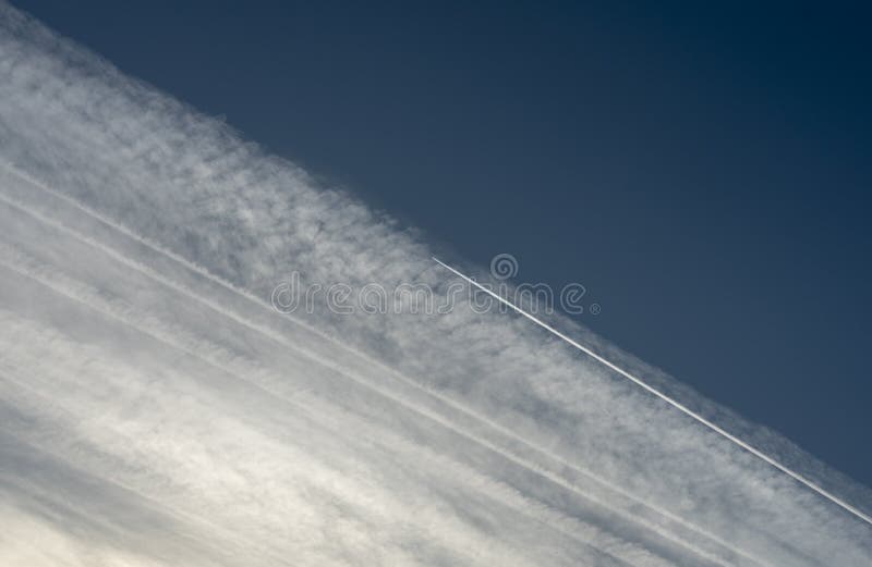Modelo de los rastros del aeroplano del aire condensado que se entrecruza contra el cielo azul fotografía de archivo libre de regalías Modelo de los rastros del aeroplano del aire condensado que se entrecruza contra el cielo azul fotografía de archivo libre de regalías