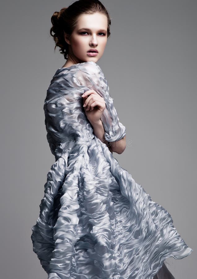 Modelo de moda hermoso que lleva el vestido de seda azul imagen de archivo libre de regalías Modelo de moda hermoso que lleva el vestido de seda azul imagen de archivo libre de regalías