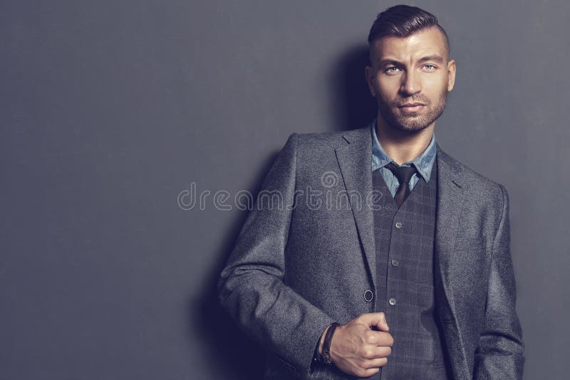 Modelo De Moda Masculino En Elegante En Gris La Pared Hombre Hermoso En Ropa Moda Retrato Del Hombre De Negocio Imagen de archivo - Imagen de atractivo, retrato: