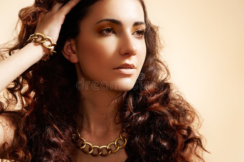 Modelo del encanto con la joyería brillante del oro, pelo del volumen imagen de archivo Modelo del encanto con la joyería brillante del oro, pelo del volumen imagen de archivo