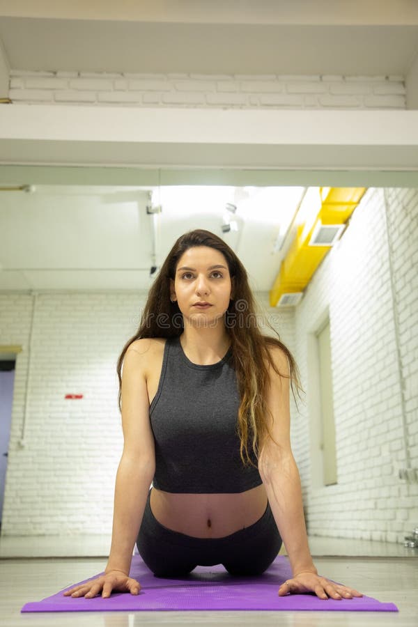 Modelo femenino atractivo en el equipo de la yoga que hace yoga foto de archivo Modelo femenino atractivo en el equipo de la yoga que hace yoga foto de archivo