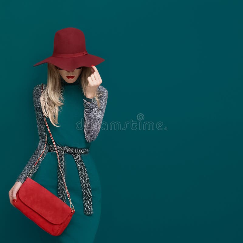 Modelo louro bonito no chapéu vermelho elegante e em uma embreagem vermelha na GR imagem de stock royalty free Modelo louro bonito no chapéu vermelho elegante e em uma embreagem vermelha na GR imagem de stock royalty free