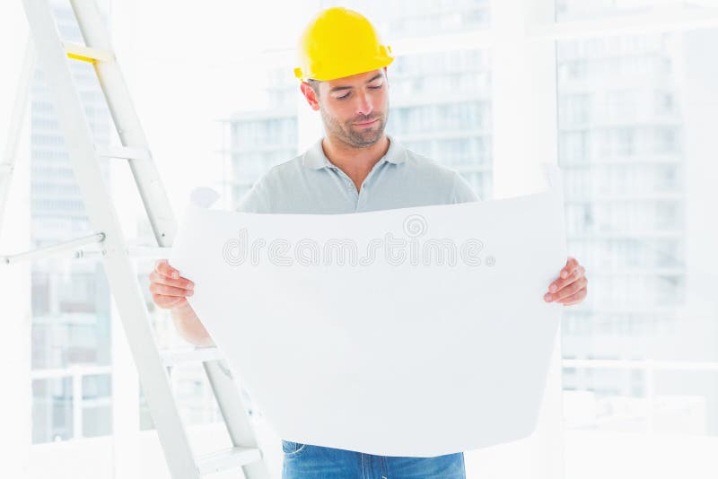 Modelo masculino da leitura do arquiteto no escritório foto de stock royalty free Modelo masculino da leitura do arquiteto no escritório foto de stock royalty free
