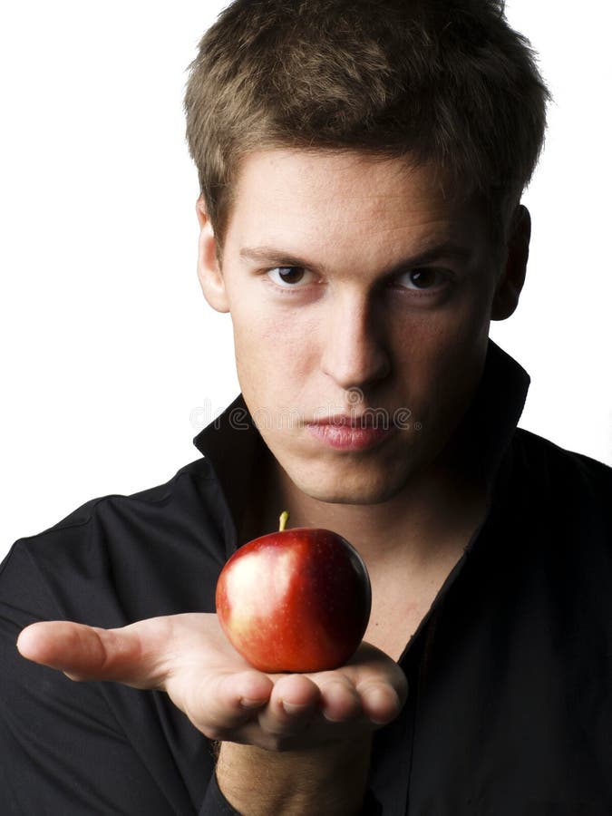 Modelo masculino joven hermoso que sostiene una manzana imagenes de archivo Modelo masculino joven hermoso que sostiene una manzana imagenes de archivo