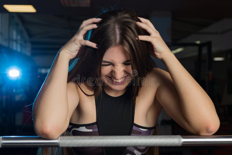 Modelo 'sexy' bonito da aptidão que levanta emocionalmente no barbell atlético no gym imagens de stock Modelo 'sexy' bonito da aptidão que levanta emocionalmente no barbell atlético no gym imagens de stock