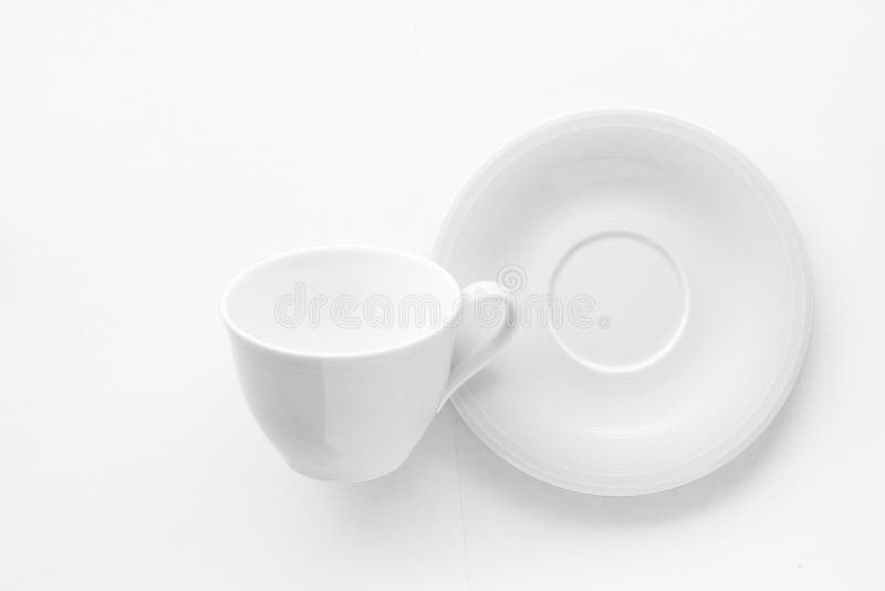 Modelo vazio do copo e dos pires no fundo branco, flatlay imagem de stock Modelo vazio do copo e dos pires no fundo branco, flatlay imagem de stock