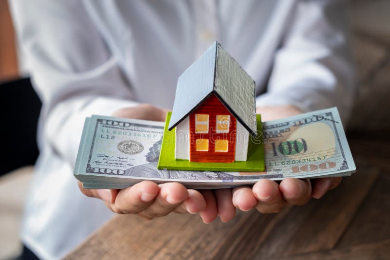 Modelo y dinero de la casa a disposición imágenes de archivo libres de regalías Modelo y dinero de la casa a disposición imágenes de archivo libres de regalías