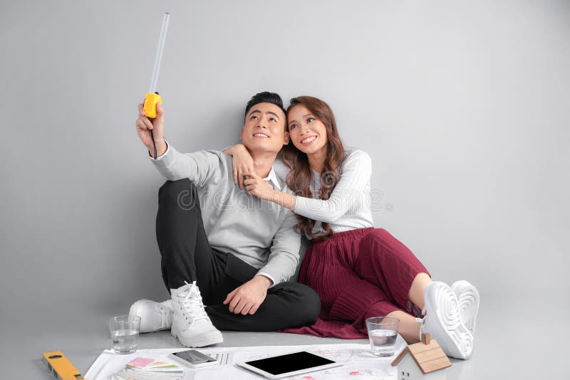 Modelos de examen de los pares jovenes de ellos nuevo hogar Propiedades inmobiliarias y concepto móvil de la casa fotos de archivo libres de regalías Modelos de examen de los pares jovenes de ellos nuevo hogar Propiedades inmobiliarias y concepto móvil de la casa fotos de archivo libres de regalías