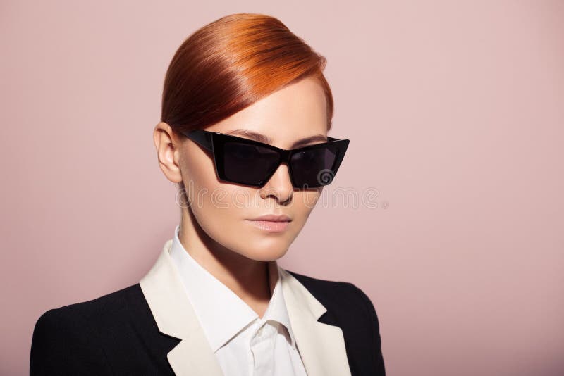 Fashion portrait of serious woman dressed as a secret agent or spy. Pink background. Fashion portrait of serious woman dressed as a secret agent or spy. Pink background.