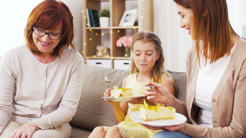 Moder, dotter och farmor som äter kakan