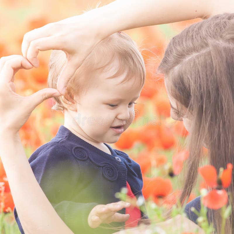 Moder med det roliga barnet som är utomhus- på vallmoblommafältet royaltyfri fotografi Moder med det roliga barnet som är utomhus- på vallmoblommafältet royaltyfri fotografi