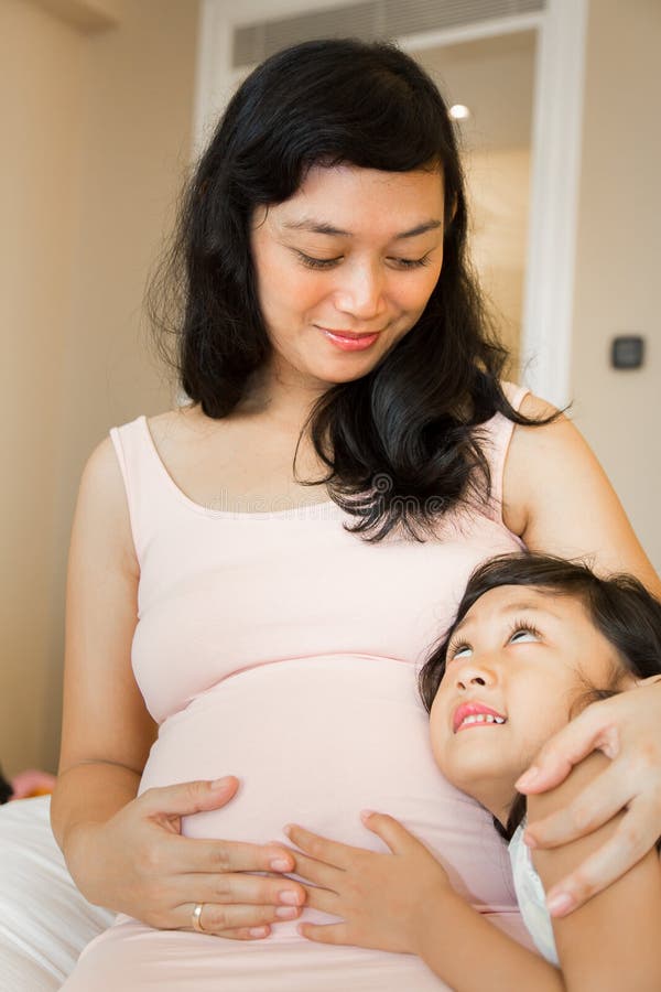 Moder och dotter för lycklig familj gravid arkivfoton Moder och dotter för lycklig familj gravid arkivfoton