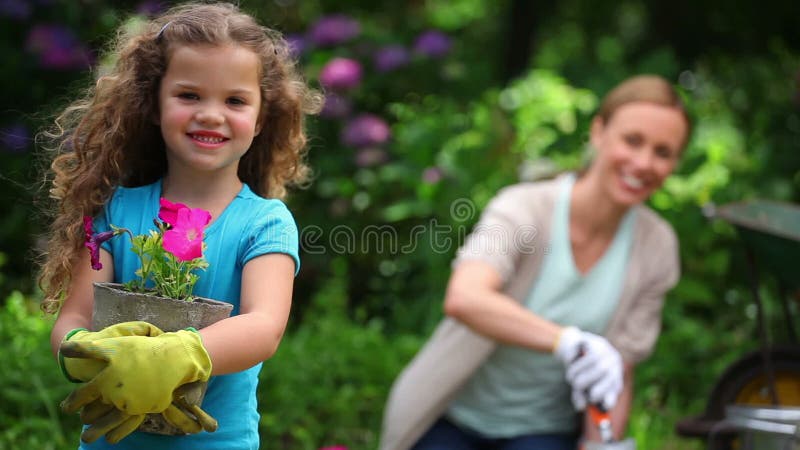 Moder och dotter som planterar blommor