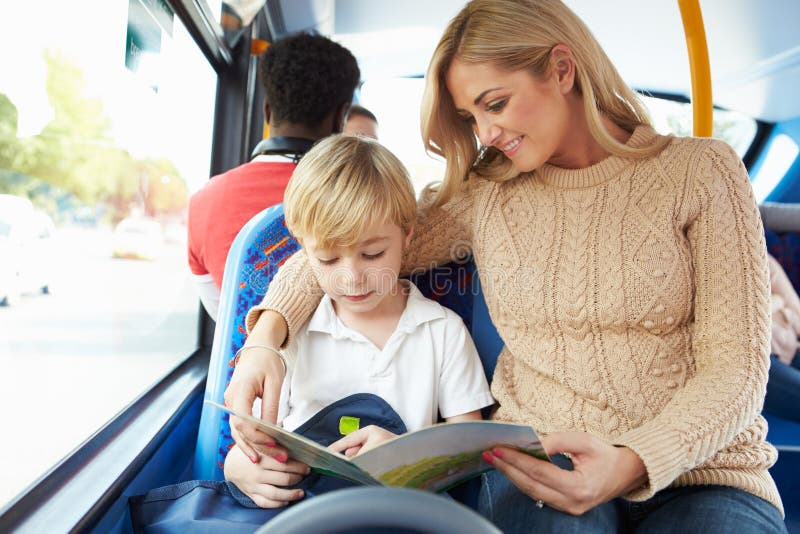 Moder och son som tillsammans går till skolan på bussen royaltyfria bilder Moder och son som tillsammans går till skolan på bussen royaltyfria bilder