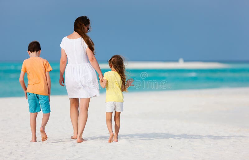 Moder och ungar på en tropisk strand royaltyfri bild Moder och ungar på en tropisk strand royaltyfri bild