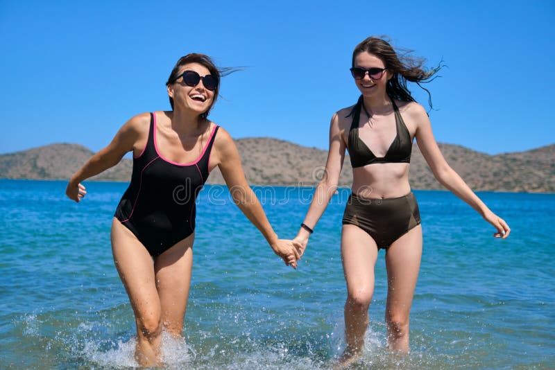 Moderdotter tillsammans på strandhållarhänderna arkivbilder
