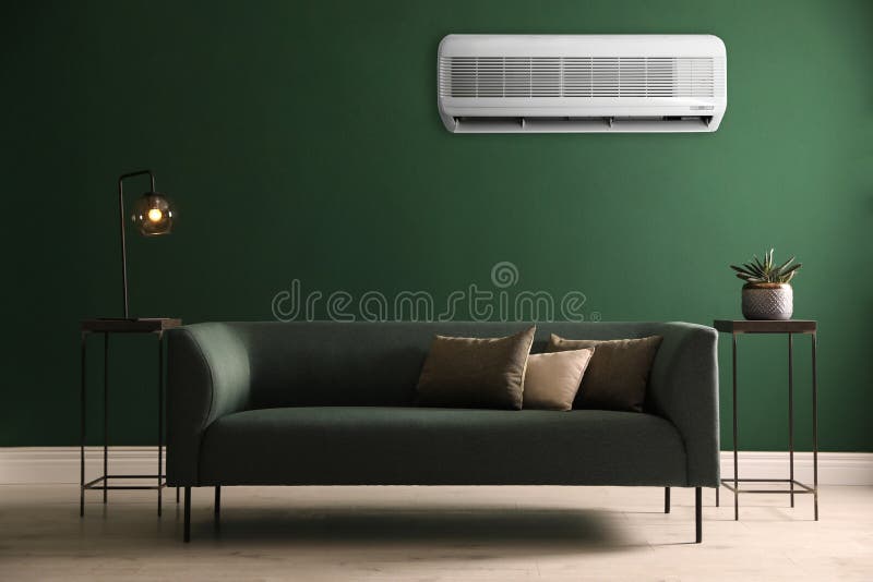 Modern Air Conditioner on Green Wall in Room with Stylish Sofa Stock