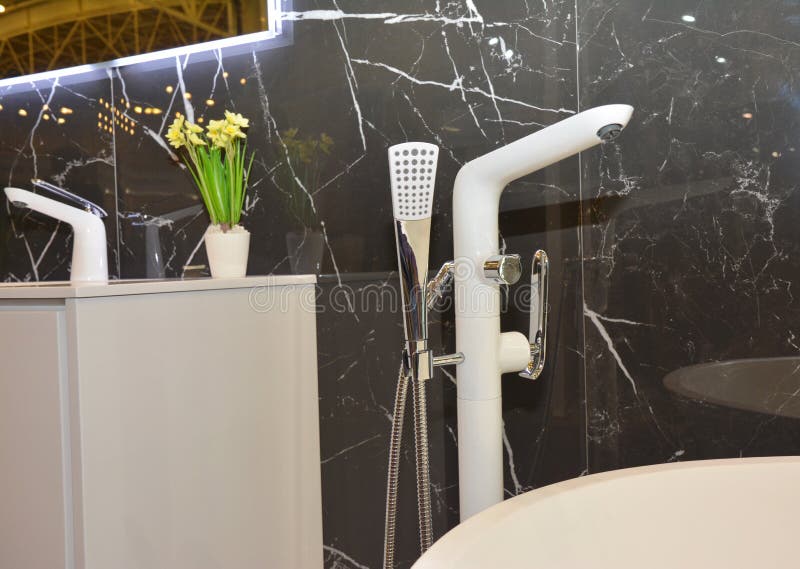 Modern baddusch med marmorväggar, badvattenkranen och badvasken arkivbilder Modern baddusch med marmorväggar, badvattenkranen och badvasken arkivbilder