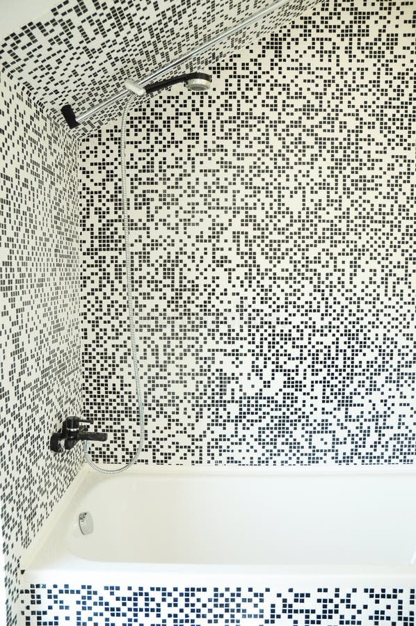 Modern bath tub with shower, chrome faucet and modern mosaic tiles royalty free stock photos Modern bath tub with shower, chrome faucet and modern mosaic tiles royalty free stock photos