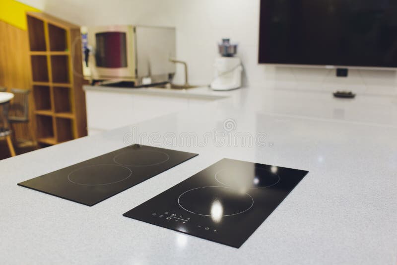 Modern Black Induction Cooker on White Countertop. Kitchen with Island