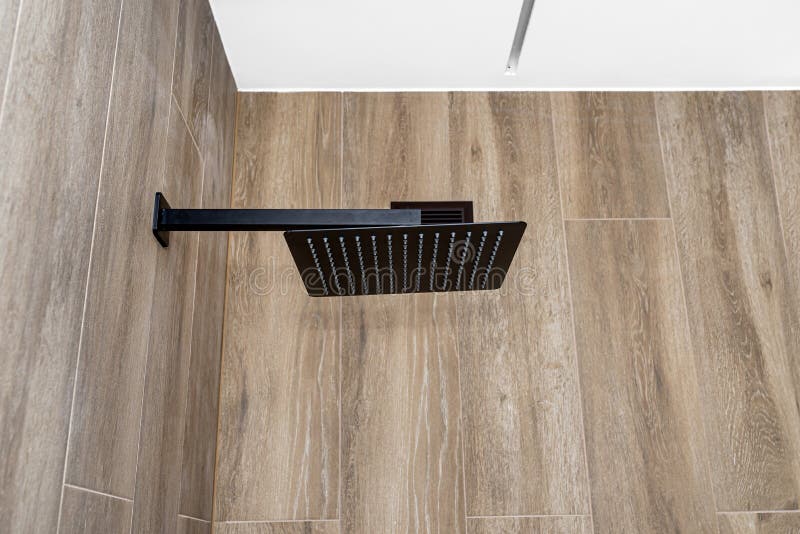 A Modern, Black Metal Concealed Shower with a Large Rain Shower, Placed