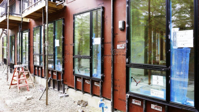 Modern building exterior showing new energy efficient windows being installed, construction site development royalty free stock photos