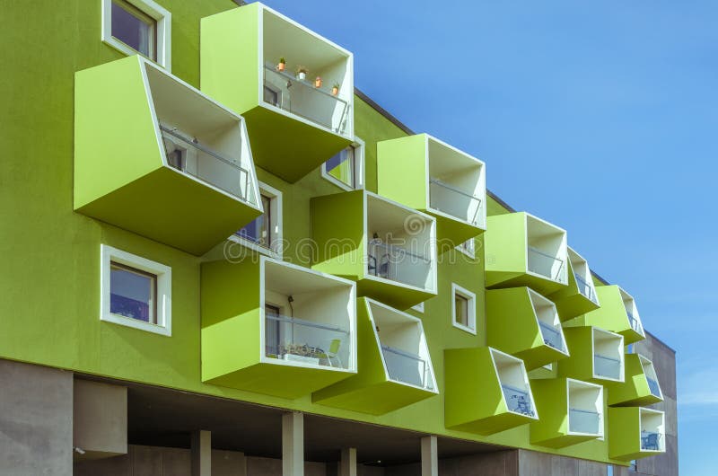 Modern building painted green with different shapes of balconies