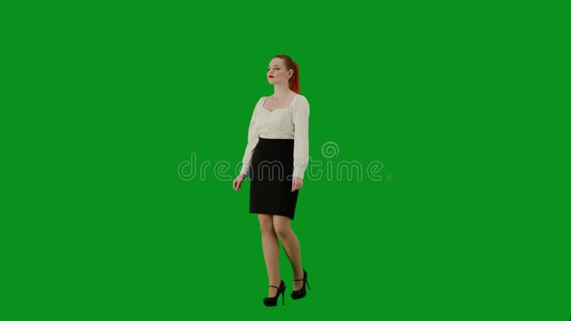 Portrait of attractive office girl on chroma key green screen. Woman in skirt and blouse walking cutely. Half turn.