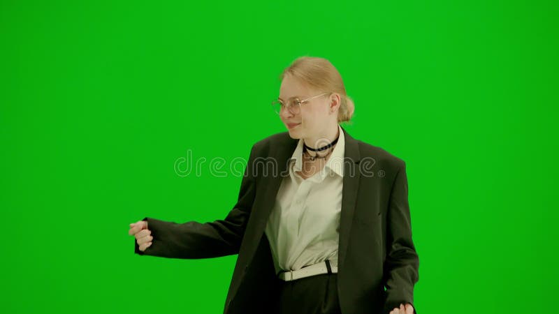 Portrait of female in suit on chroma key green screen. Blonde business woman in formal outfit walking and dancing. Half