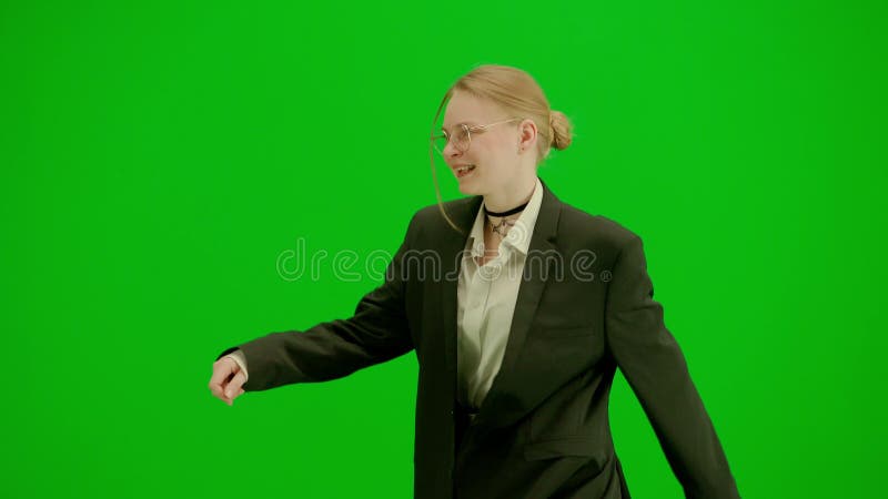 Portrait of female in suit on chroma key green screen. Blonde business woman in formal outfit walking and dancing. Half