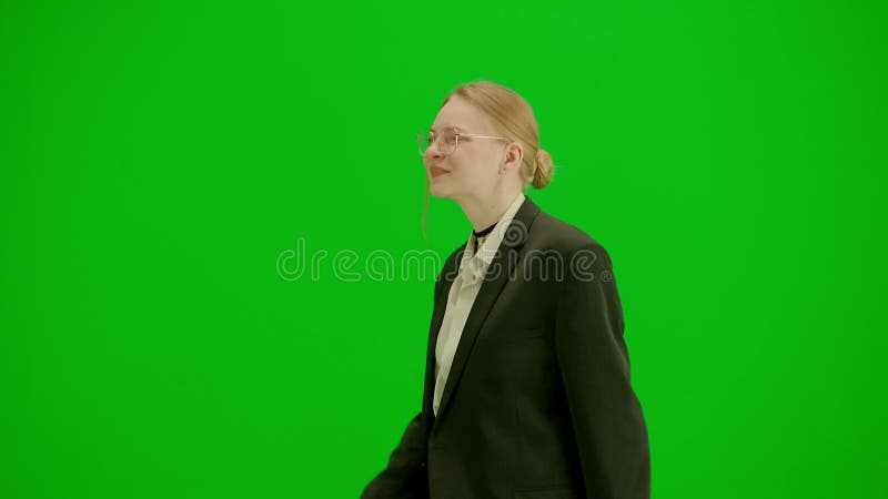 Portrait of female in suit on chroma key green screen. Blonde business woman in formal outfit walking and dancing. Half