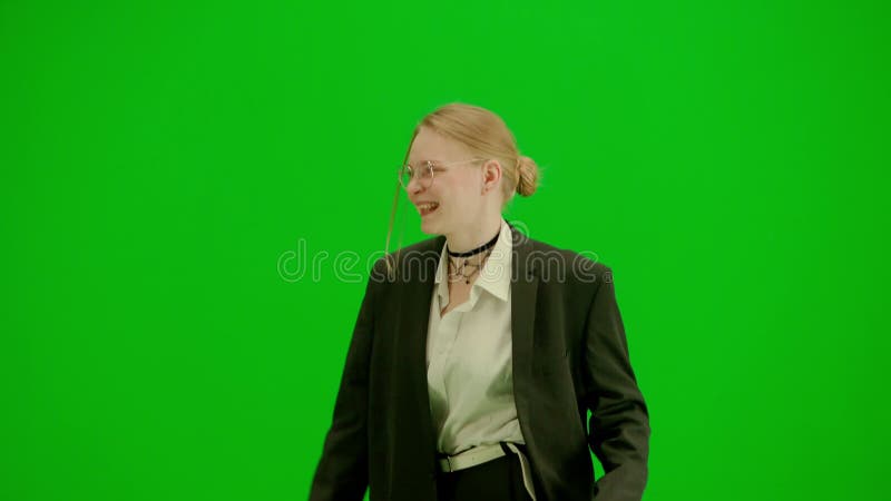 Portrait of female in suit on chroma key green screen. Blonde business woman in formal outfit walking and dancing. Half