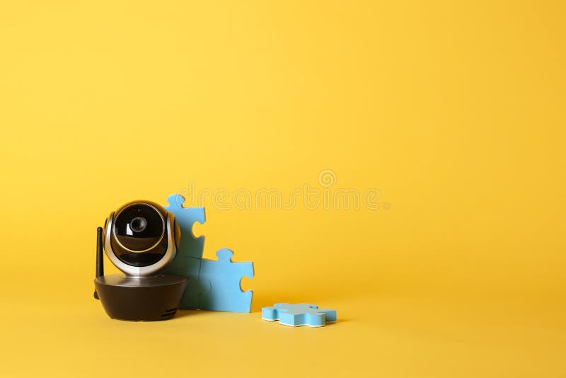 Modern CCTV Security Camera and Child Puzzle on Color Background. Stock