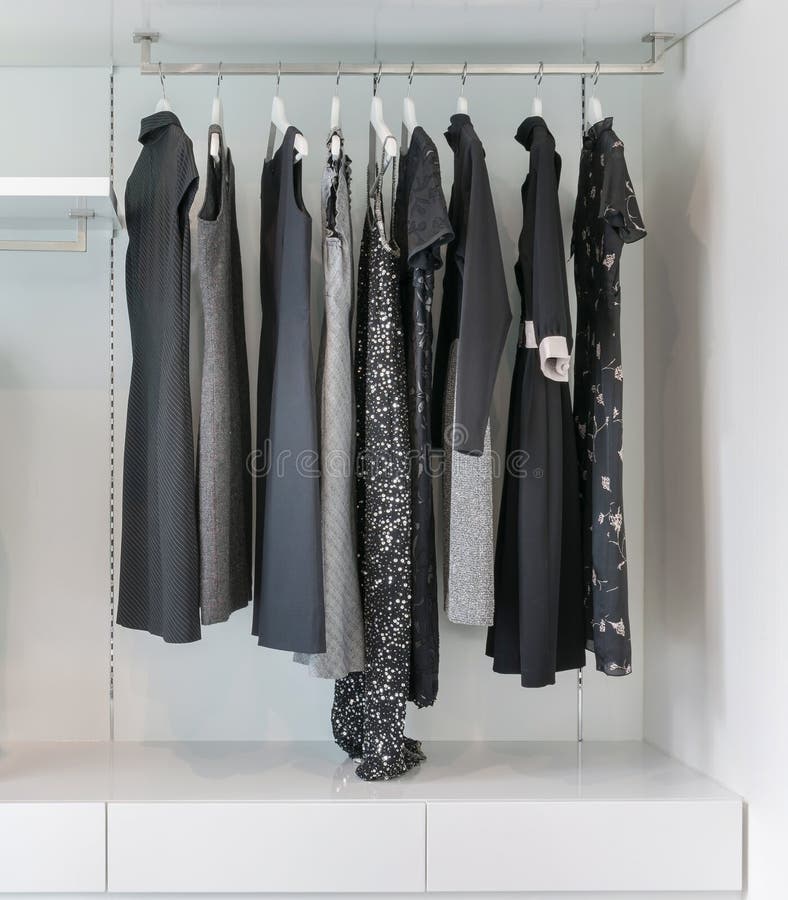 Modern Closet with Row of Black Dress Hanging in White Wardrobe Stock