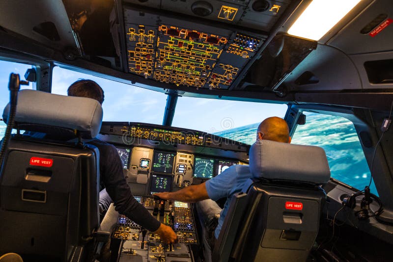 Modern cockpit för flygplan i flygbussen med piloter under en träningssession i en simulator för full flygning
