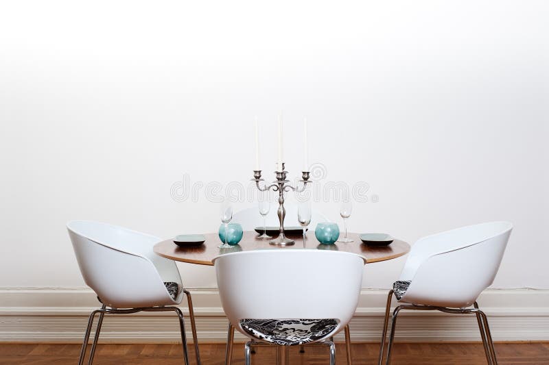 Moderna sala da pranzo con tavolo rotondo e sedie bianche e sfondo.