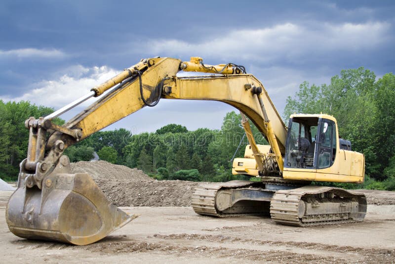 Large Yellow Back Hoe at Construction site. Storm brewing. Track hoe construction excavator stock images, royalty-free photos and pictures