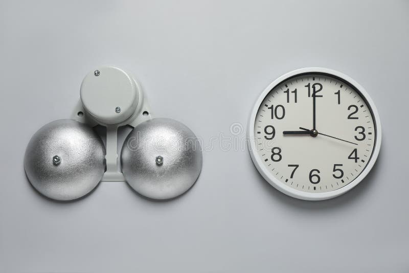 Modern electrical school bell and clock on white wall stock photography