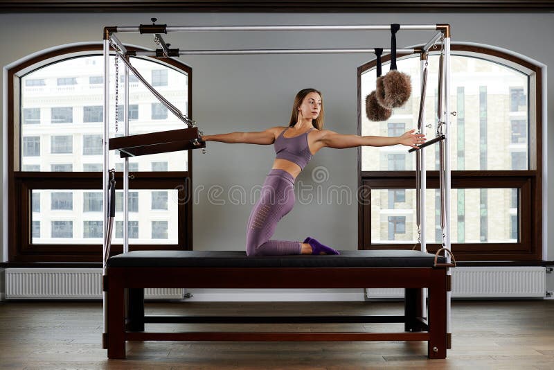 Modern equipment Cadilac reformer for Pilates in the gym, Concept of health and rehabilitation, instructor performs