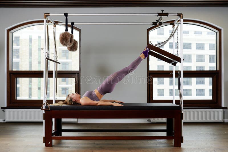 Modern equipment Cadilac reformer for Pilates in the gym, Concept of health and rehabilitation, instructor performs